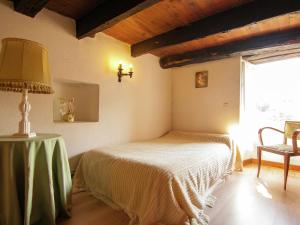a bedroom with a bed and a table with a lamp at Tasteful Cottage in Roziers with Terrace in Lissac-sur-Couze