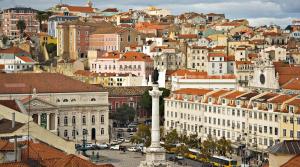 Blick auf eine Stadt mit Gebäuden und einem Uhrturm in der Unterkunft Rossio Sunny City View in Lissabon