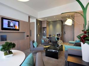a living room with a couch and a tv at Novotel Avignon Centre in Avignon