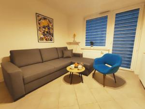 - un salon avec un canapé et un fauteuil bleu dans l'établissement Apartament Milbertus, à Sandomierz