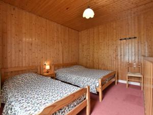 two beds in a room with wooden walls at Apartment in La Bresse with Ski Storage Garden Terrace BBQ in La Bresse