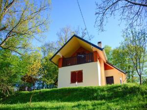 a small house on top of a grassy hill at Lovely holiday house with big private garden in Tuhelj