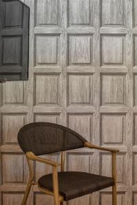 una sedia in legno seduta di fronte a un muro di Casa do Rio a Mondim de Basto