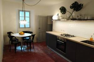 uma cozinha com uma mesa, um fogão e uma mesa com cadeiras em Rocks apartment Colonno em Colonno