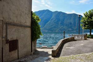 a stone building with a staircase next to a body of water at Rocks apartment Colonno in Colonno