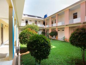 a courtyard of an apartment building with a green yard at RedDoorz Syariah Plus @ Wisma Bougenville Karawaci in Tangerang