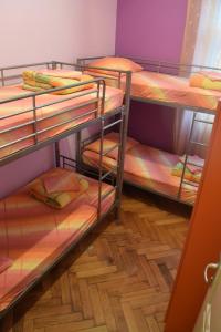 three bunk beds in a room with a wooden floor at Old Town Hostel Split in Split