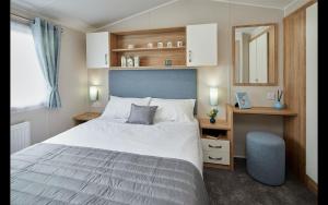 卡迪根的住宿－Cardigan Bay Holiday Park，卧室配有一张白色大床和镜子