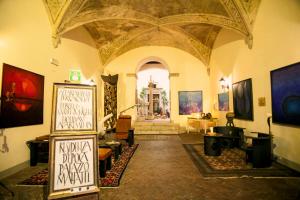 Großes Zimmer mit einer großen Decke und Gemälden an den Wänden in der Unterkunft Residenza d'Epoca Palazzo Malfatti in Massa Marittima