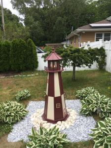 a lighthouse in the middle of a yard at Brushwood House by Smith Point Beach in Shirley