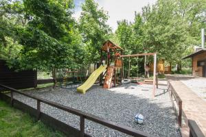 a playground with a slide and a swing set at Shalet Greystone in Estosadok