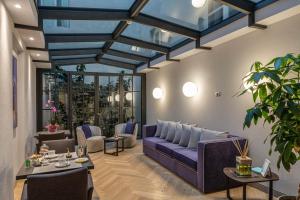 a living room with a purple couch and tables at Palazzo Dipinto in Lucca