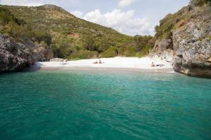una playa con gente en la arena y el agua en Hotel Residence il villaggio Lì cylentos Policastro Scario a 100 mt dal mare, en Policastro Bussentino