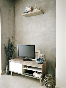 uma televisão num armário de madeira num quarto em Apartment Walnut103 with pool em Pafos