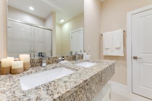 a bathroom with two sinks and a mirror at Magic Village Yards Trademark Collection by Wyndham in Orlando