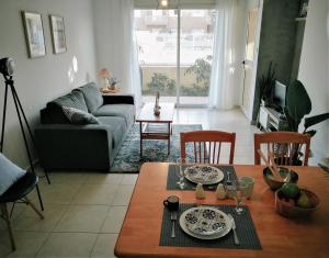 uma sala de estar com uma mesa e um sofá em Apartment Walnut103 with pool em Pafos