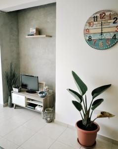 uma sala de estar com um vaso de plantas e um relógio em Apartment Walnut103 with pool em Pafos
