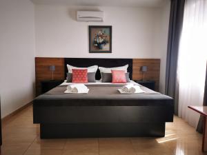 a bedroom with a large black bed with red pillows at Apartment Marco in Makarska +30 photos