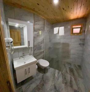 a bathroom with a sink and a toilet and a mirror at Cirali Villas 2 in Cıralı