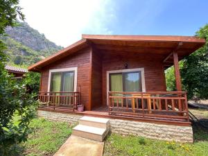 a log cabin with a porch and a balcony at Cirali Villas 2 in Cıralı