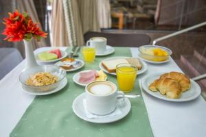 uma mesa coberta com chávenas de café e pratos de comida em Hostal Santa Fe De La Veracruz em Santa Fé