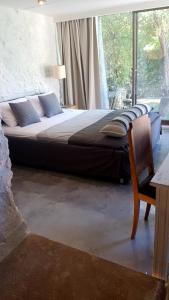 een slaapkamer met een bed met een stoel en een raam bij FEEL LIKE HOME IN LESVOS in Mytilini