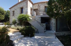 a stone house with a staircase in front of it at FEEL LIKE HOME IN LESVOS in Mytilini