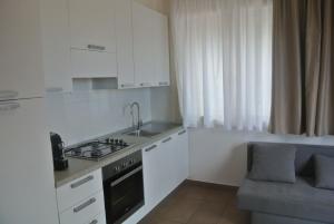 una cucina bianca con lavandino e piano cottura di Rinaldi House a Torriana