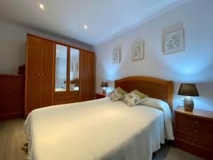 a bedroom with a white bed and a window at A Barquiña de Margarita - vacaciones frente al mar in Noya