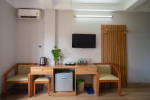 a room with a desk and two chairs and a tv at Candy Hotel in Ha Long