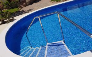 a blue swimming pool with a staircase in it at Beach Resort La Margarita in Hospitalet de l'Infant