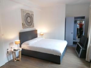 Schlafzimmer mit einem weißen Bett und einem Spiegel in der Unterkunft Hotel Gamper in Bellinzona