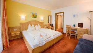 a hotel room with a bed and a desk at Pension St.Leonhard in Bad Gastein