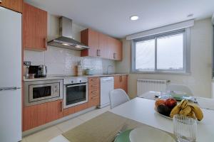 eine Küche mit einem Tisch mit einer Obstschale darauf in der Unterkunft Blue Ocean Penthouse in A Coruña