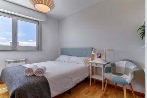 een slaapkamer met een bed, een bureau en een stoel bij Blue Ocean Penthouse in A Coruña