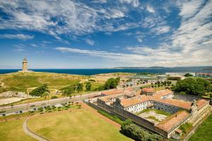 an aerial view of a building with a lighthouse on a hill at Blue Ocean Penthouse in A Coruña