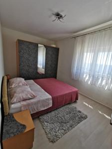 Schlafzimmer mit einem Bett und einem Deckenventilator in der Unterkunft Apartment Nera in Omiš