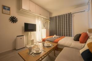 a room with two beds and a table and a tv at Raku in Fujisawa