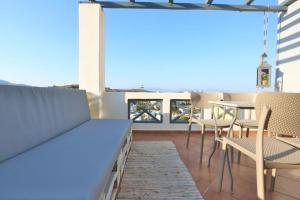 a patio with chairs and a table on a roof at Aegean Emerald in Azolimnos
