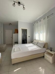 a large white bedroom with a large white bed at Rooms Chrysoula in Nea Vrasna