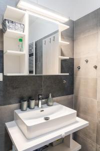 bagno con lavandino bianco e specchio di Apartment Lucy - Primo Tatry Starý Smokovec a Starý Smokovec