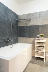 a bathroom with a white tub and a shower at Apartment Lucy - Primo Tatry Starý Smokovec in Starý Smokovec