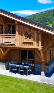 a large wooden building with a table and chairs at Chalet luxe L'HIBISCUS in Samoëns