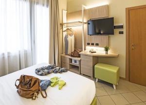 Hotel Ostuni في ريميني: غرفة في الفندق سرير وعليها شنطة