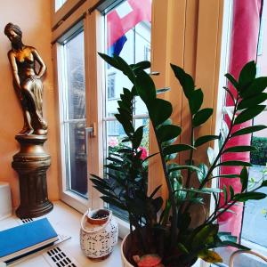biurko z posągiem i rośliną w oknie w obiekcie Esos Hotel Quelle w mieście Bad Ragaz