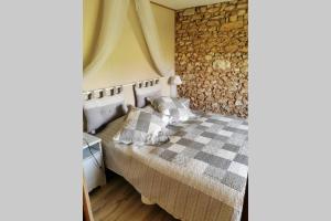 um quarto com uma cama com uma parede de pedra em Manoir Vaillant Gîte au cœur du Périgord noir em Monplaisant