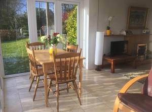 a dining room with a table and chairs and a fireplace at Woodford Guest House in old farm in Killarney