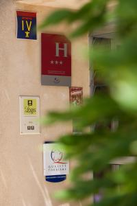 a close up of signs on the side of a building at Logis Hôtel Castel Mouisson in Barbentane