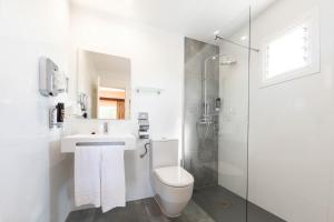 a bathroom with a toilet and a sink and a shower at Hostal Neptuno in Paguera