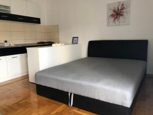 uma cama grande num quarto com uma cozinha em Studio Apartman NENA em Vrnjačka Banja
